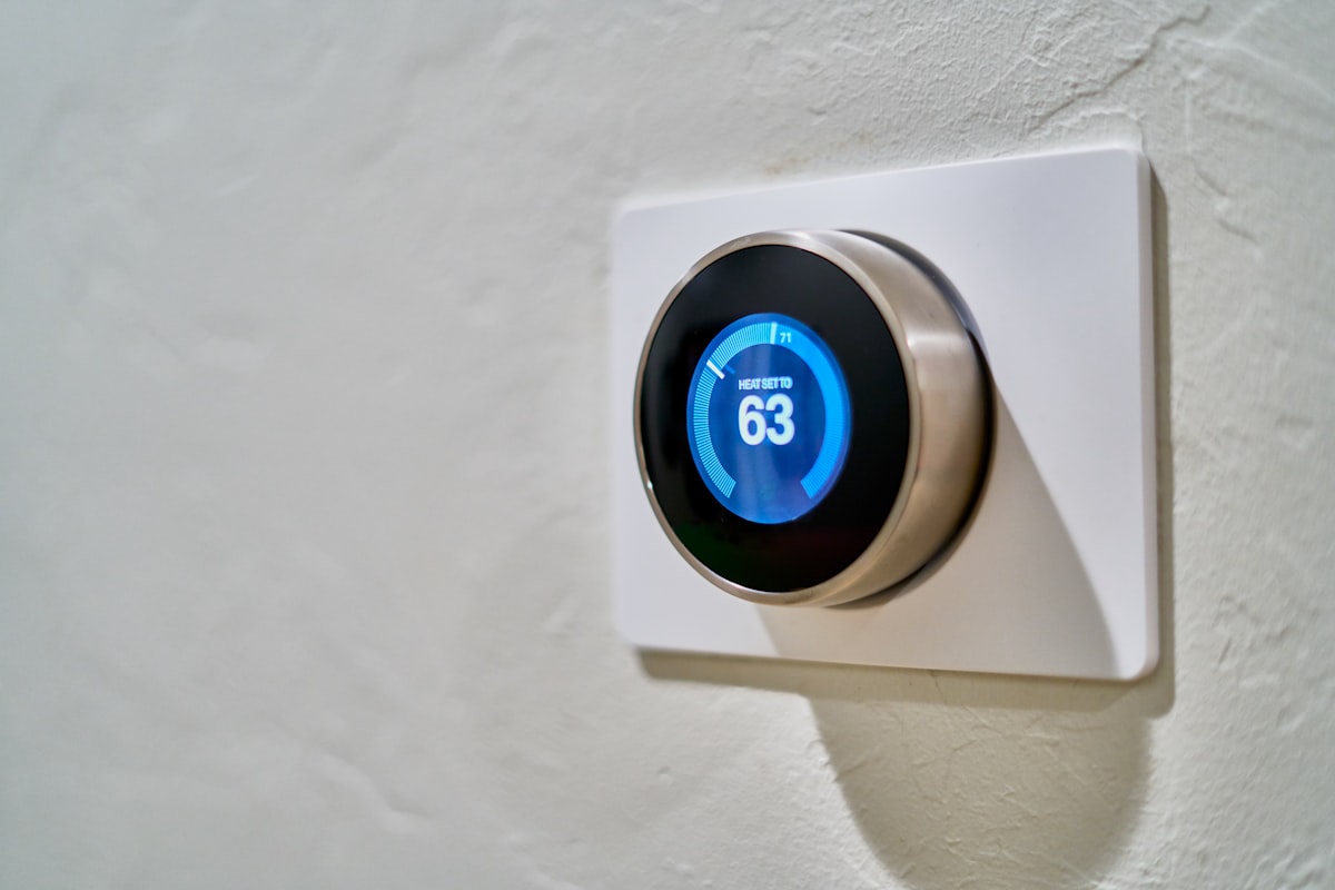Modern Nest smart thermostat displaying temperature on a clean interior wall