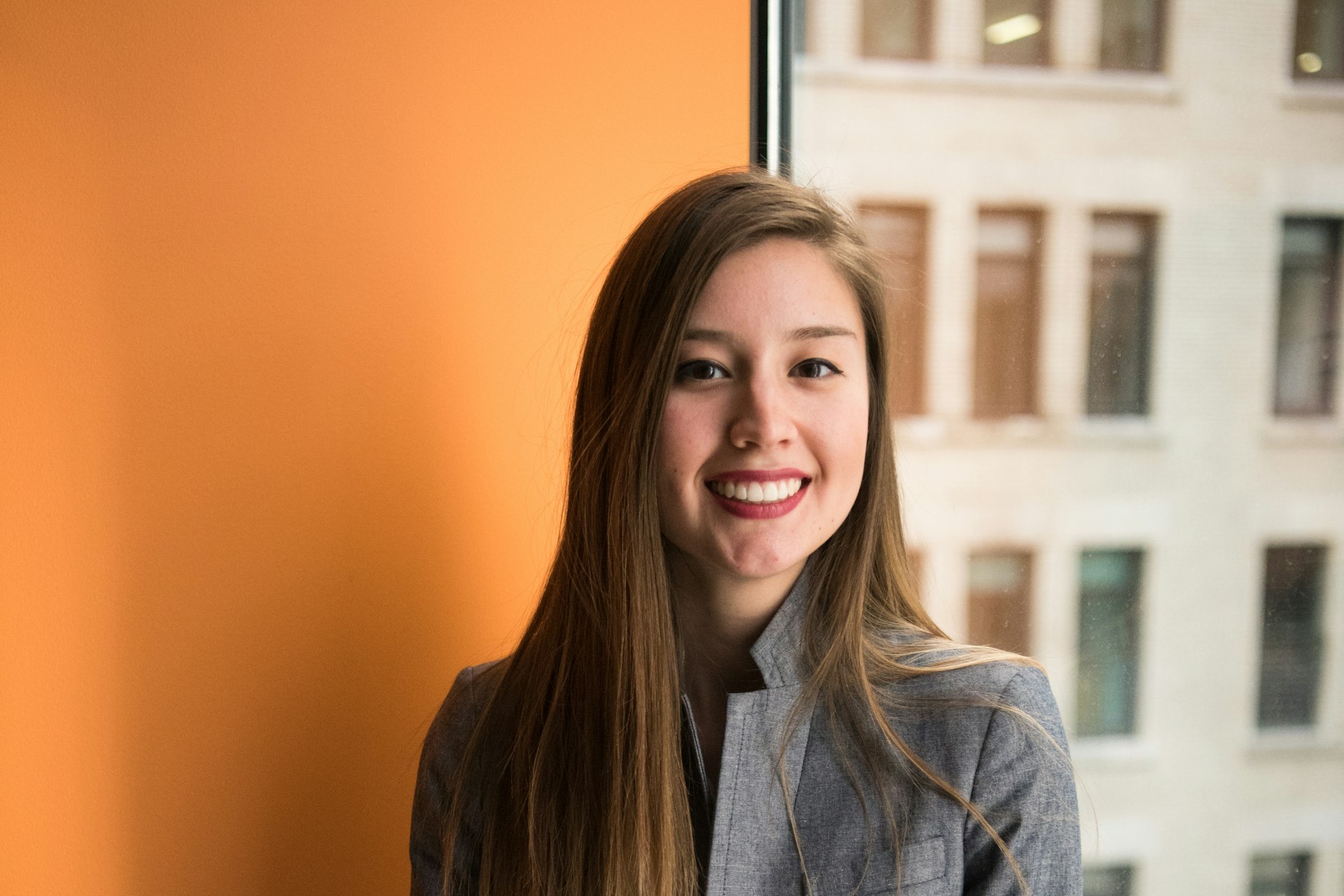 Maria Lopez, Facilities Coordinator, standing confidently in a modern office environment